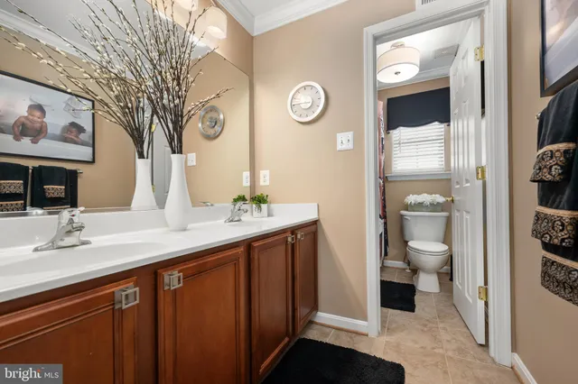 a bathroom with a granite countertop toilet sink and mirror
