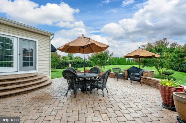 a view of a backyard with table and chairs under an umbrella