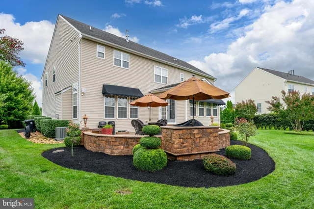a view of a house with a backyard and sitting area