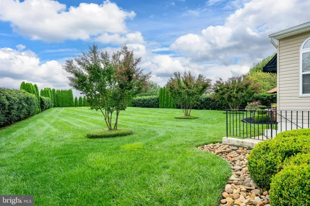 a front view of a house with garden and flowers