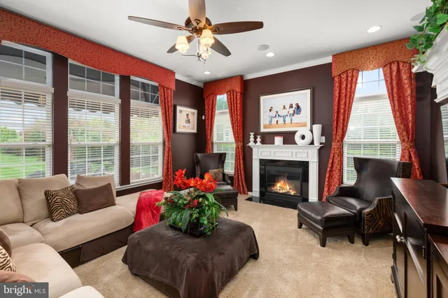 a living room with furniture a fireplace and a large window