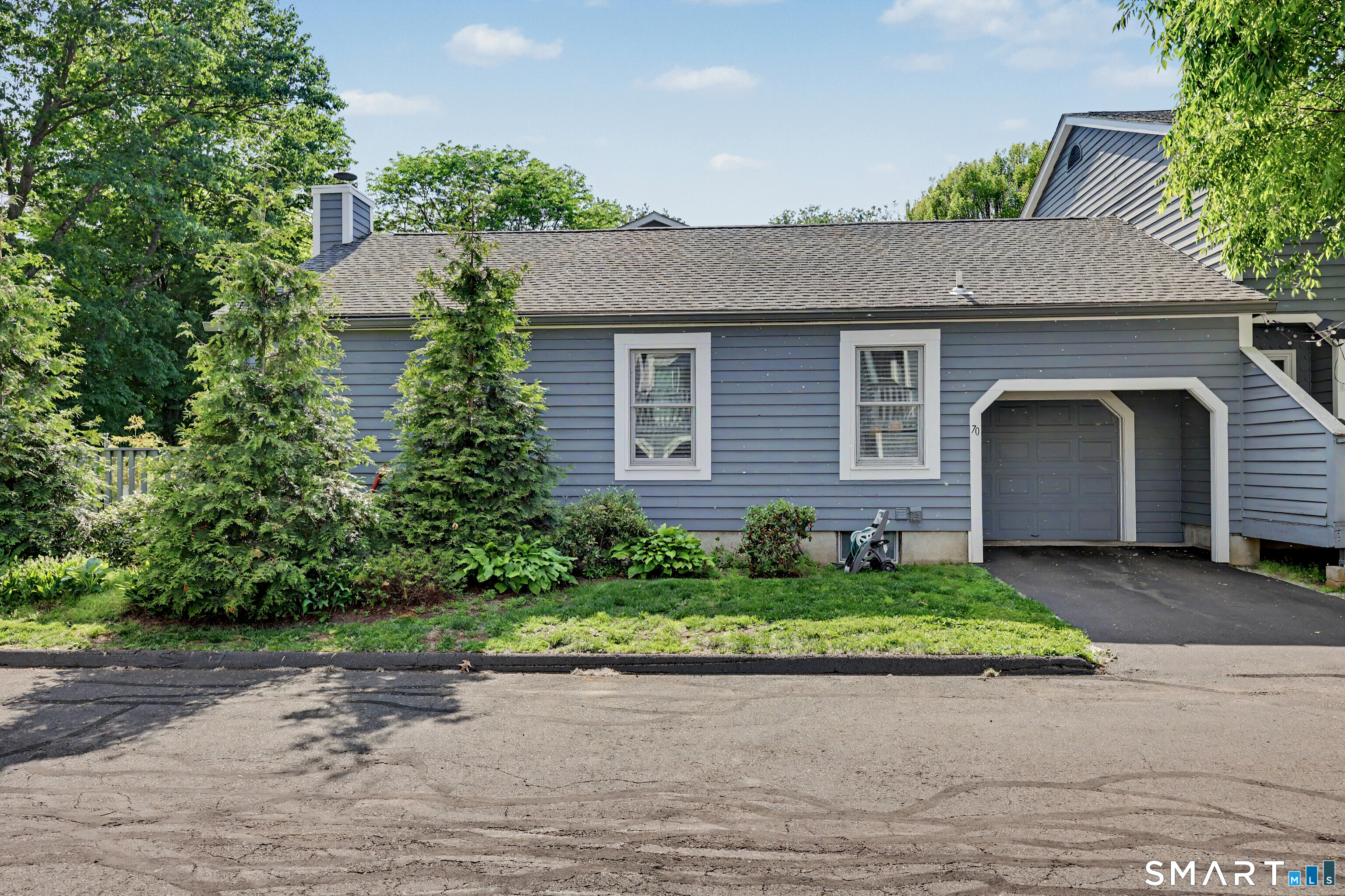 70 Fawn Ridge Lane, Unit 70 Norwalk, CT 06851 - Photo 28 of 36 a front view of a house with a yard and garage