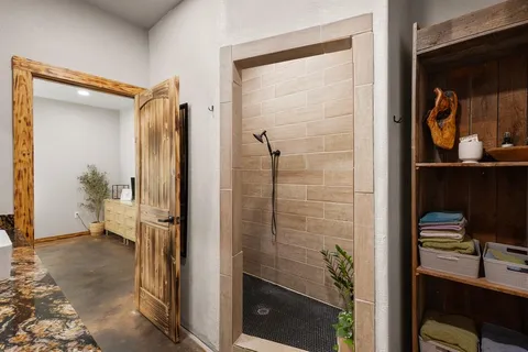 a bathroom with a granite countertop sink toilet a mirror and shower curtain