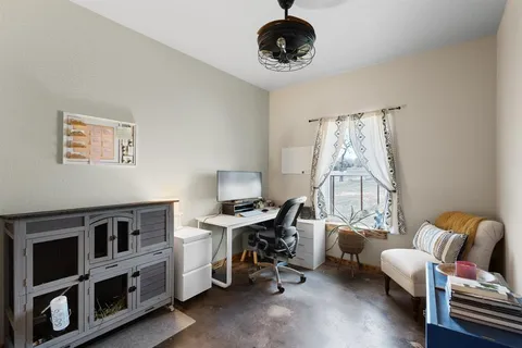 a view of a workspace with furniture and a window