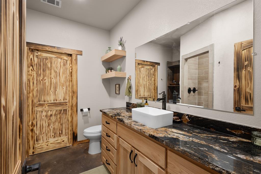 1501 Huddleston Road Sunset, TX 76270 - Photo 10 of 17 a spacious bathroom with a granite countertop sink and a mirror