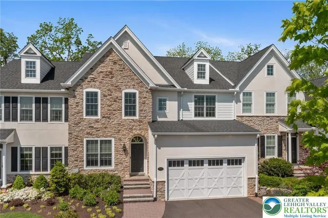 a front view of a house with a yard and trees