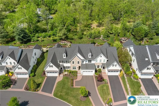 an aerial view of residential houses with outdoor space and trees