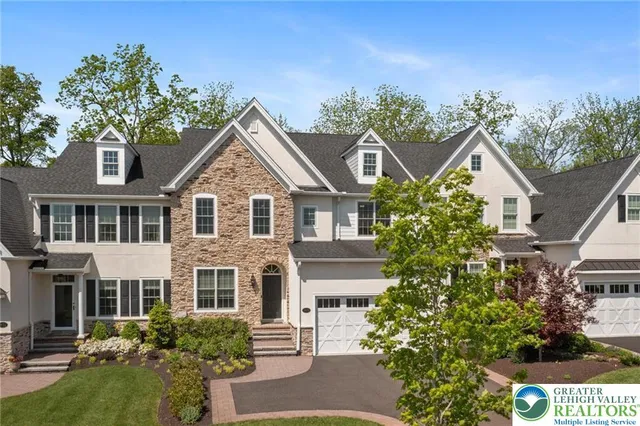 a front view of a house with a yard and trees