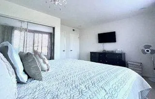 a bedroom with a bed and a flat screen tv