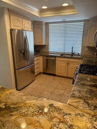 a kitchen with granite countertop a refrigerator and a sink