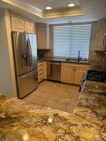 a kitchen with granite countertop a refrigerator and a sink