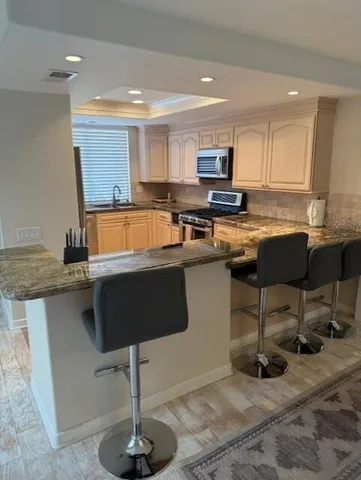 a kitchen with stainless steel appliances granite countertop a table chairs sink and cabinets