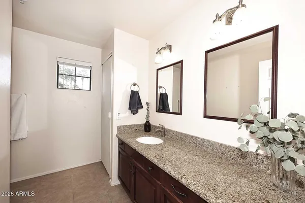 a spacious bedroom with a bed a couch and a ceiling fan