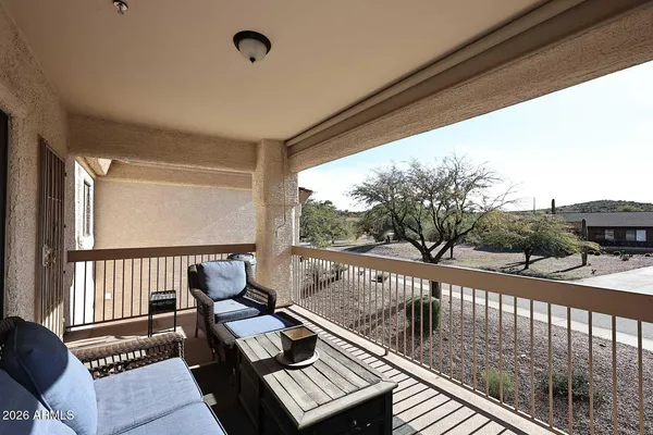 a view of a balcony with couch and chairs