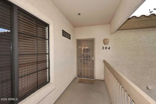 a view of a house with wooden stairs and a large tree