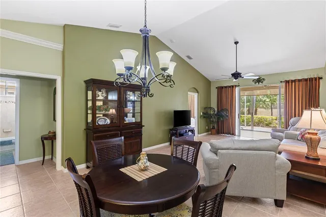 a dining room with furniture a chandelier and window