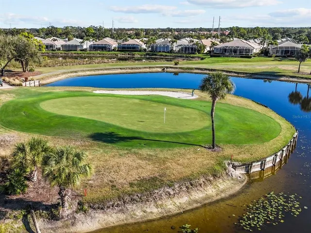 an aerial view of a residential houses with outdoor space and lake view