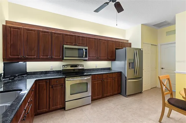 a kitchen with stainless steel appliances granite countertop a refrigerator stove and sink