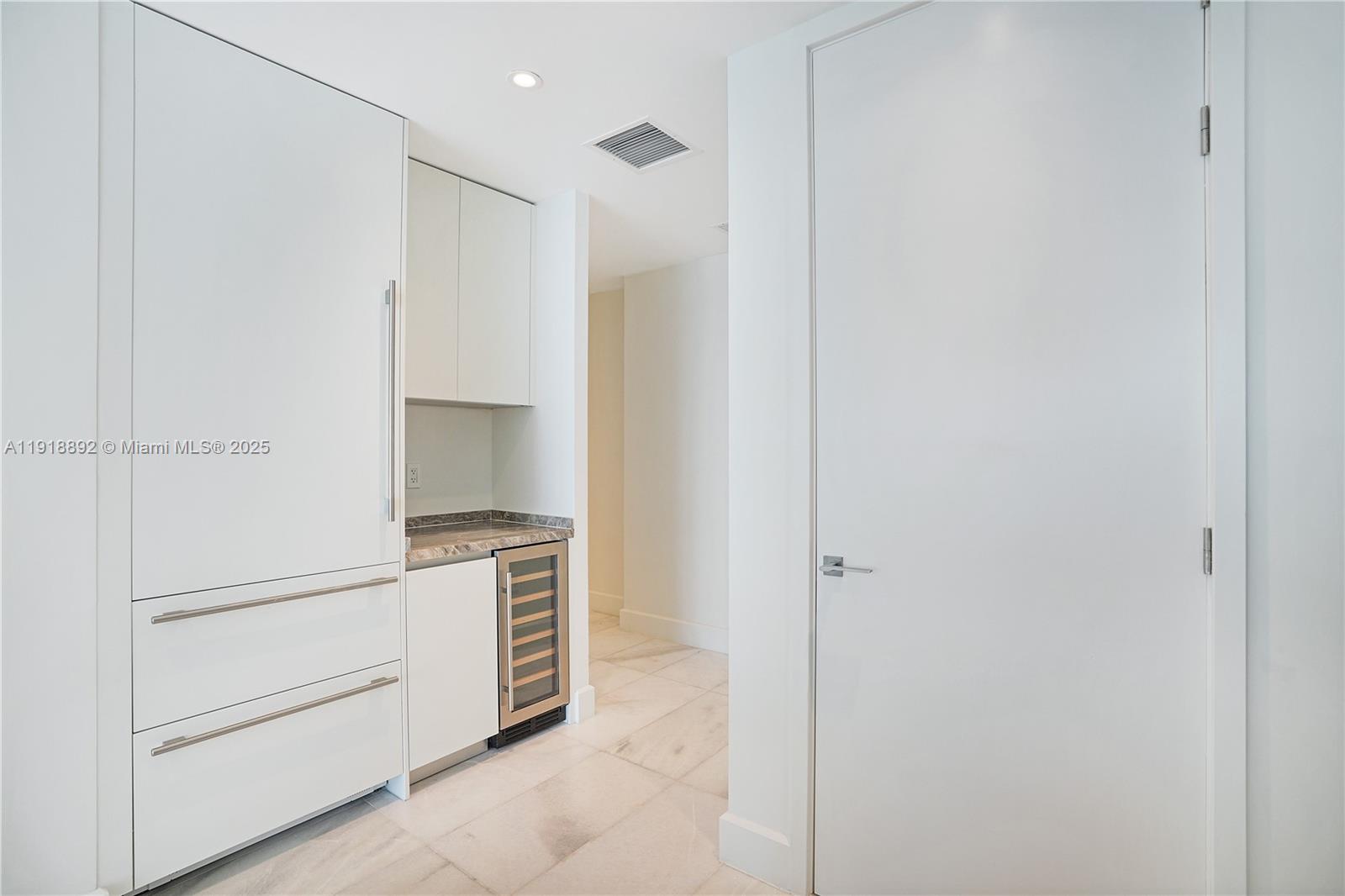 700 Northeast 26th Terrace, Unit 3604 Miami, FL 33137 - Photo 11 of 35 a kitchen with white cabinets and white appliances