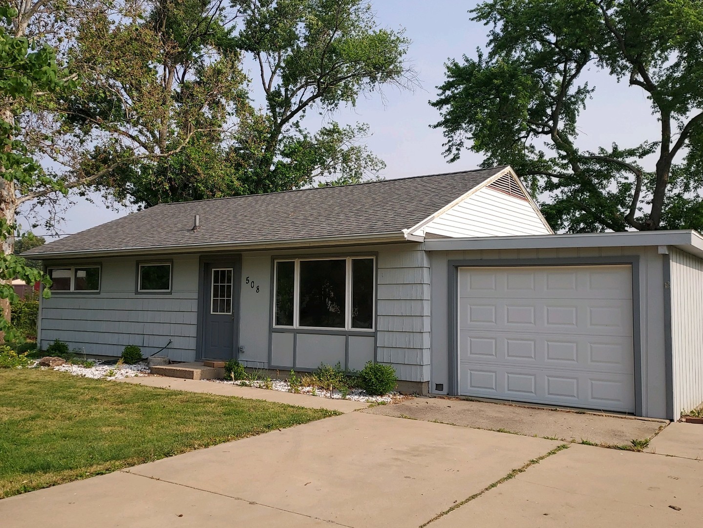 a front view of a house with a garden and yard