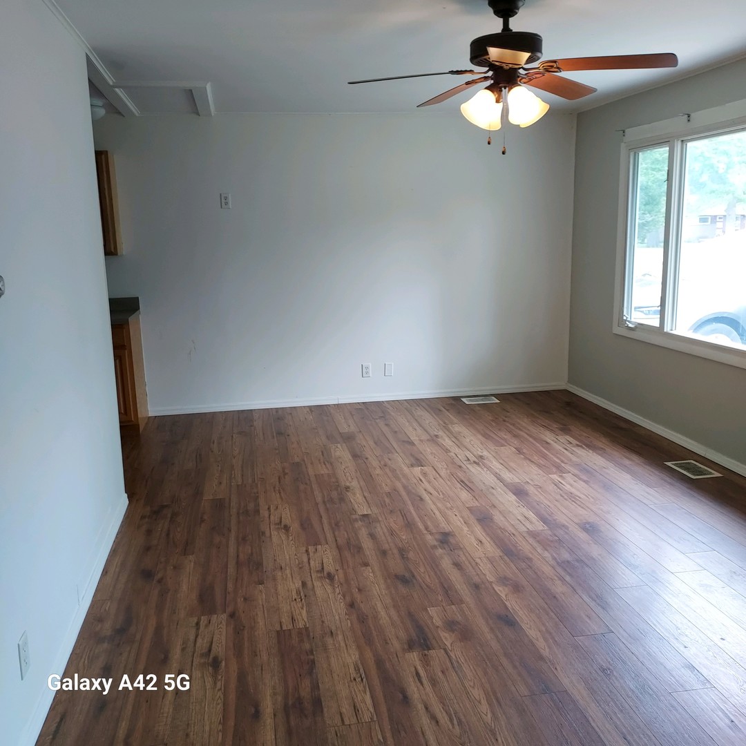 508 East North Line Road Tuscola, IL 61953 - Photo 2 of 12 wooden floor in an empty room with a window