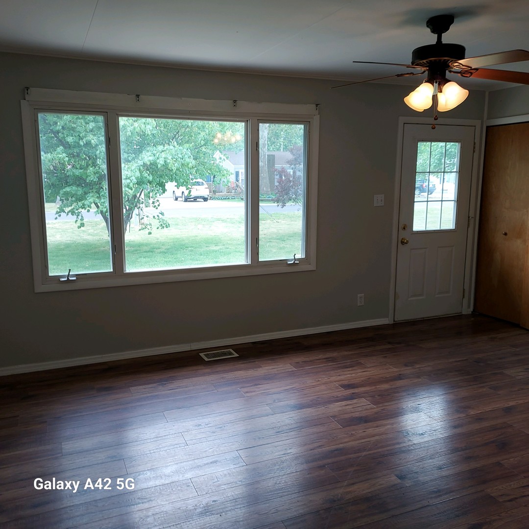508 East North Line Road Tuscola, IL 61953 - Photo 3 of 12 a view of an empty room with wooden floor and a window