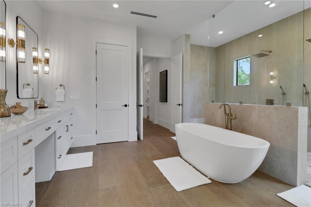 538 13th Street Southwest Naples, FL 34117 - Photo 4 of 15 a spacious bathroom with a double vanity sink a mirror and a bathtub