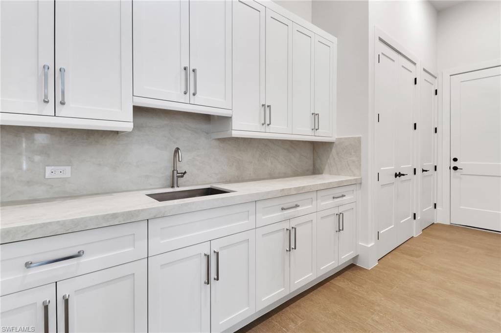 538 13th Street Southwest Naples, FL 34117 - Photo 9 of 25 a kitchen with white cabinets and a sink
