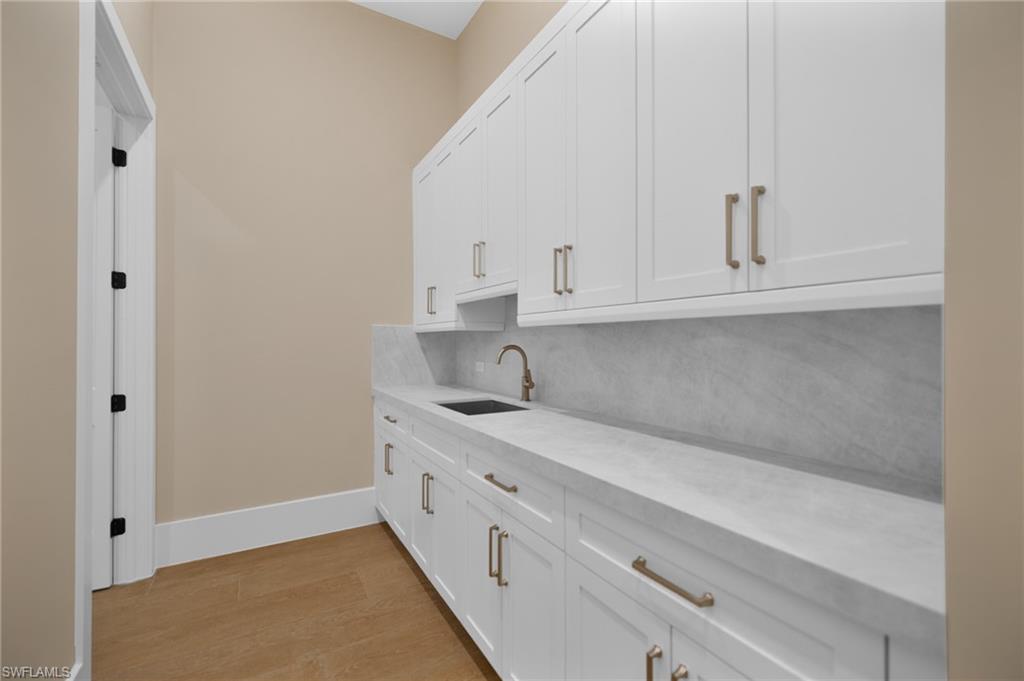 538 13th Street Southwest Naples, FL 34117 - Photo 10 of 25 a kitchen with white cabinets and sink
