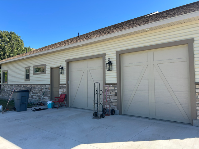 2688 Read Lane Preston, ID 83263 - Photo 2 of 18 Two-car garage featuring carriage-style doors, stone veneer accents, and exterior wall lanterns