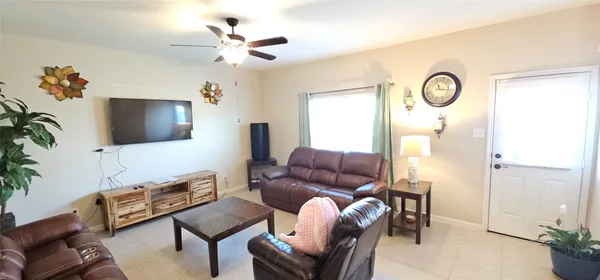 a living room with furniture a flat screen tv and a window
