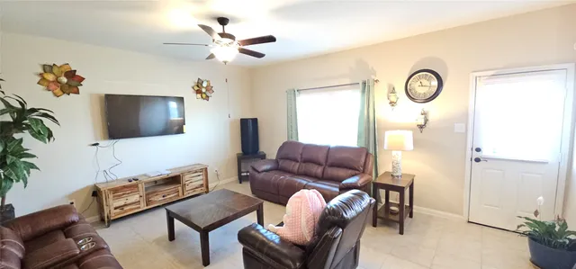 a living room with furniture a flat screen tv and a window