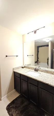 a bathroom with a granite countertop sink and a mirror