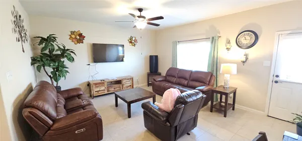 a living room with furniture a flat screen tv and a potted plant