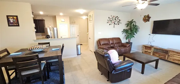 a living room with furniture a flat screen tv and a potted plant