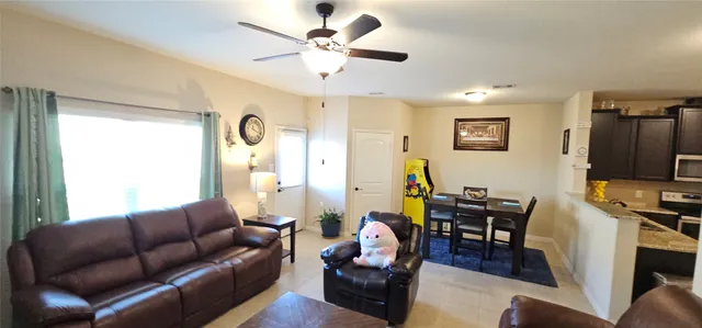 a living room with furniture ceiling fan and a window