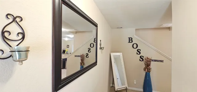 a view of a hallway with wooden floor and stairs