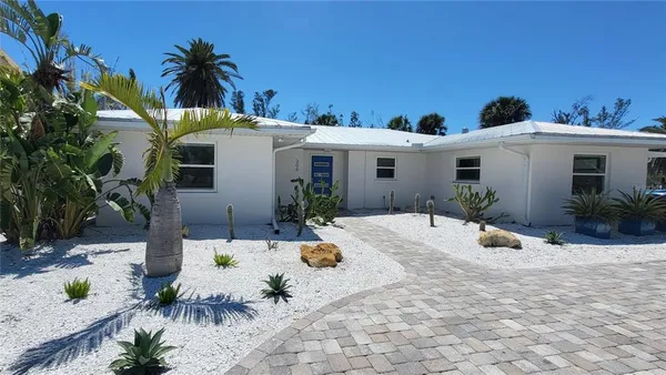a view of a white house with a swimming pool and sitting area