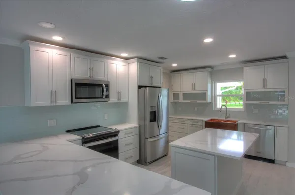 a kitchen with stainless steel appliances a refrigerator sink and microwave