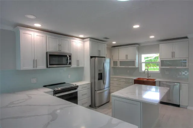 a kitchen with stainless steel appliances a refrigerator sink and microwave