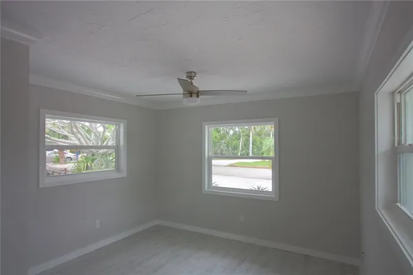 an empty room with windows and fan
