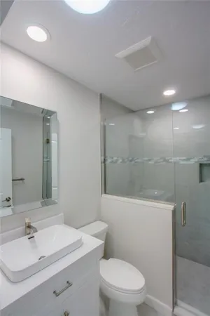 a bathroom with a sink a toilet and shower