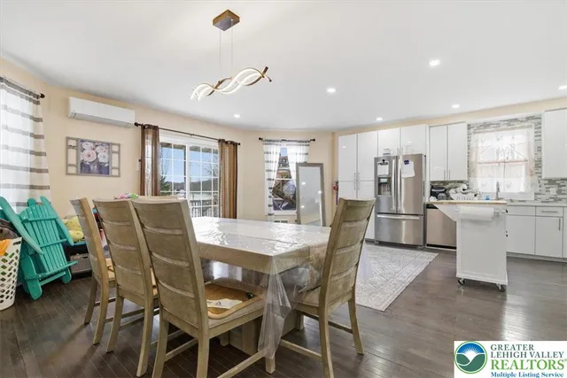 a view of hallway with wooden floor and a bathroom