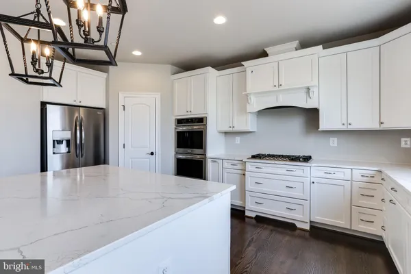 a kitchen with stainless steel appliances white cabinets and a refrigerator