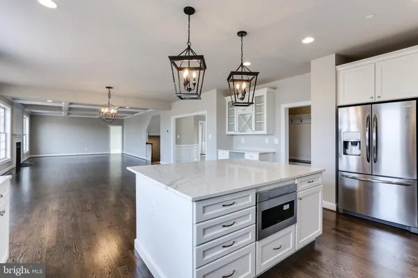 a kitchen with kitchen island white cabinets and stainless steel appliances