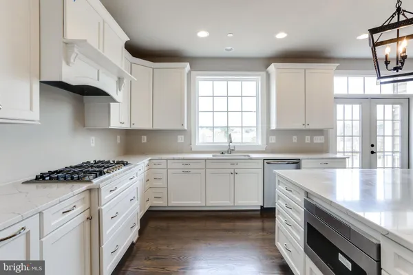 a kitchen with stainless steel appliances granite countertop a stove a sink and a white cabinets