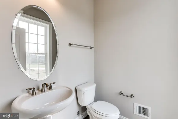a white toilet sitting next to a bathroom sink