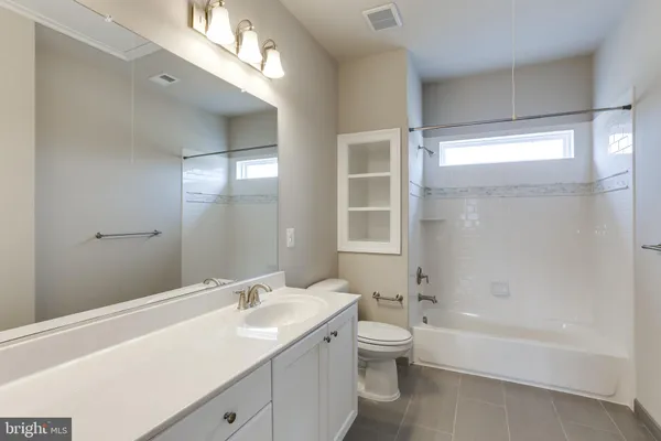 a bathroom with a granite countertop sink a toilet and bathtub