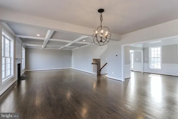 a view of empty room with wooden floor and window