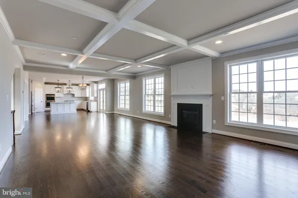 an empty room with wooden floor and a fireplace